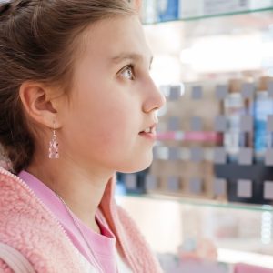 photo of a teenage girl looking at a pharmacy shelf (isotretinoin)