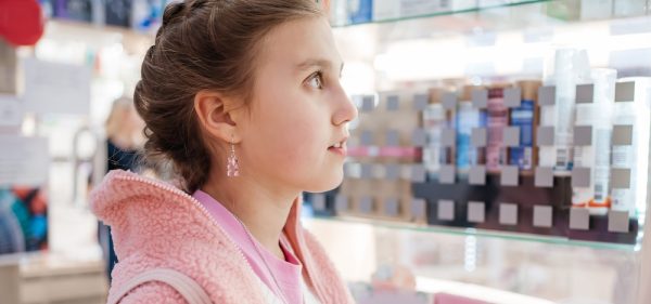 photo of a teenage girl looking at a pharmacy shelf (isotretinoin)