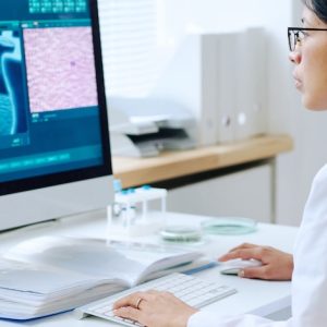 image of a young dermatologist looking into computer screen examining skin problems