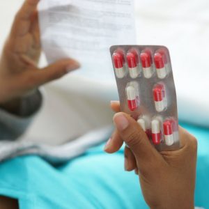 image of woman holding pills and reading instructions