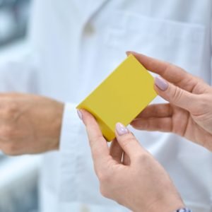 patient looking at medication in a pharmacy (presumably for treating shingles)