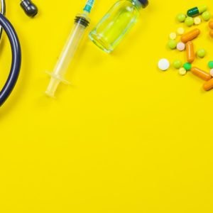 image with pills and medical devices on yellow background