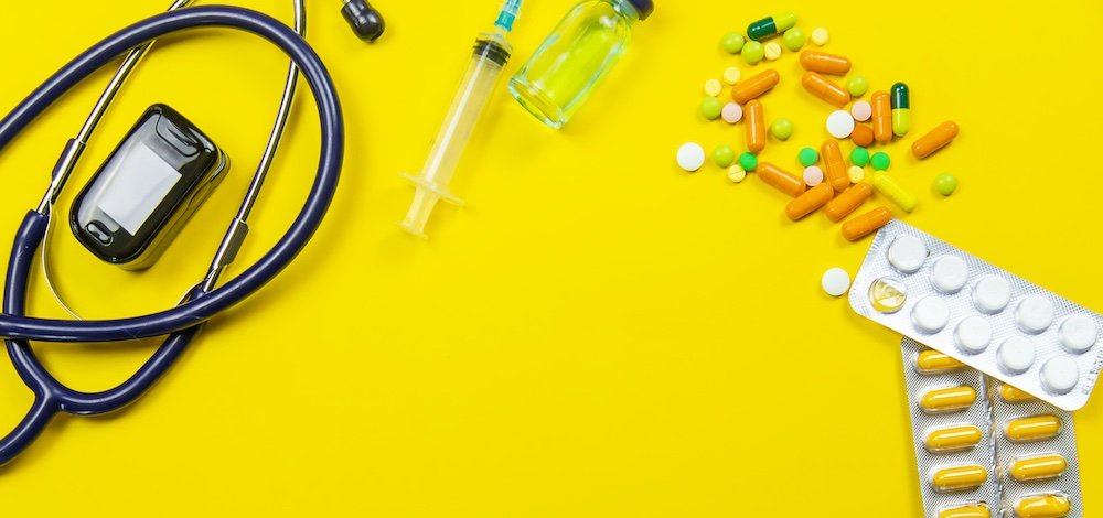 image with pills and medical devices on yellow background